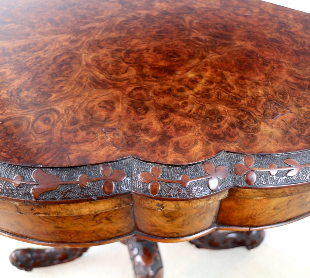 A pair of Victorian burr walnut fold-over card tables featuring shaped demi-lune tops, carved aprons, central turned pedestals, and carved quadform legs with castors. View XXVIII