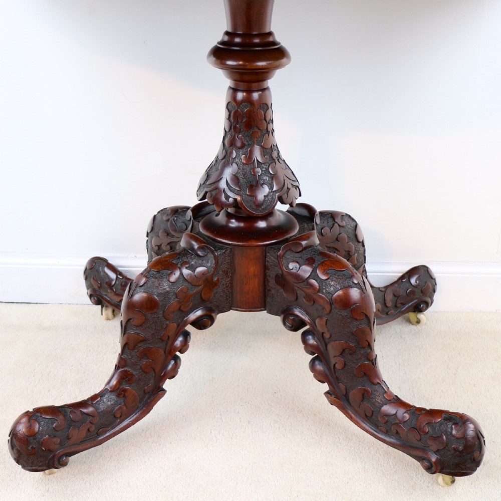 A pair of Victorian burr walnut fold-over card tables featuring shaped demi-lune tops, carved aprons, central turned pedestals, and carved quadform legs with castors. View XXX