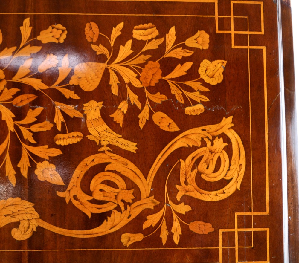 A 19th-century Dutch walnut bombe bureau decorated with intricate floral marquetry, featuring a slant front and curved drawers with brass handles. View VI