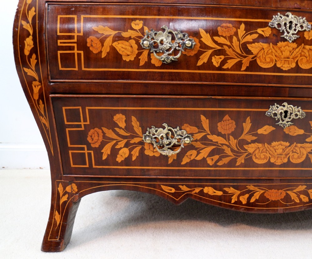 A 19th-century Dutch walnut bombe bureau decorated with intricate floral marquetry, featuring a slant front and curved drawers with brass handles. View XIII
