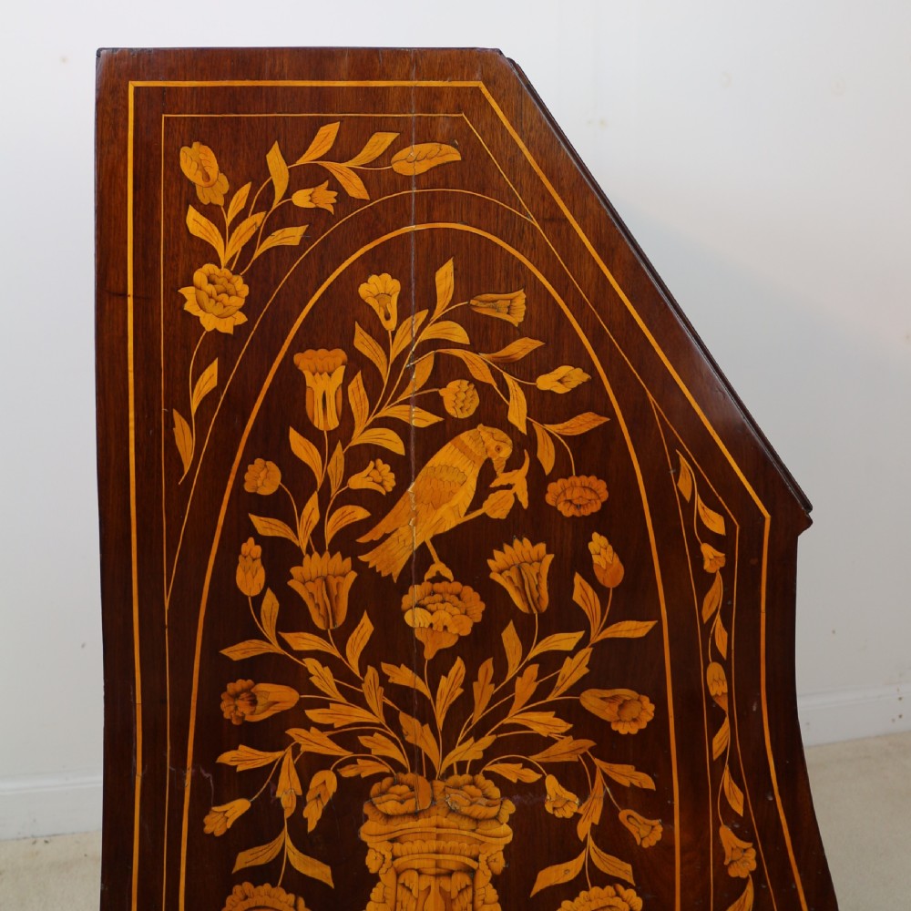 A 19th-century Dutch walnut bombe bureau decorated with intricate floral marquetry, featuring a slant front and curved drawers with brass handles. View XVII