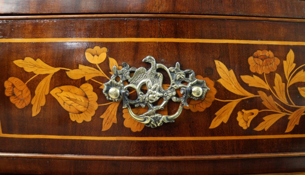 A 19th-century Dutch walnut bombe bureau decorated with intricate floral marquetry, featuring a slant front and curved drawers with brass handles. View XVIII