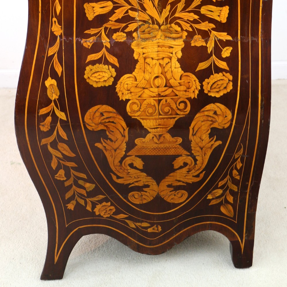 A 19th-century Dutch walnut bombe bureau decorated with intricate floral marquetry, featuring a slant front and curved drawers with brass handles. View XX