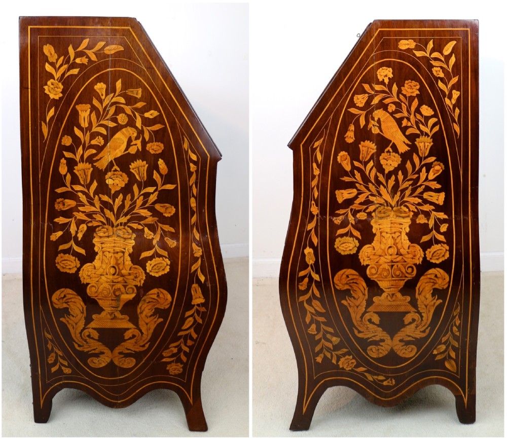 A 19th-century Dutch walnut bombe bureau decorated with intricate floral marquetry, featuring a slant front and curved drawers with brass handles. View XXI
