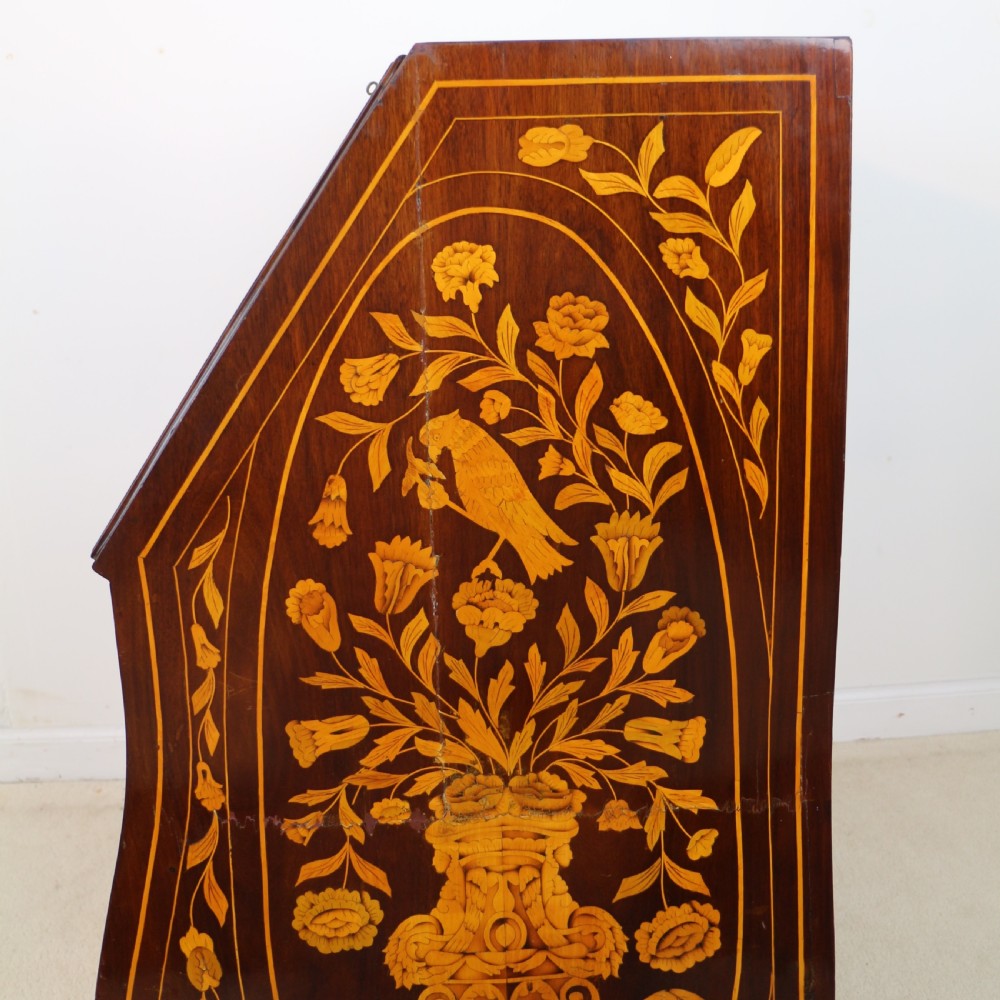 A 19th-century Dutch walnut bombe bureau decorated with intricate floral marquetry, featuring a slant front and curved drawers with brass handles. View XXIII