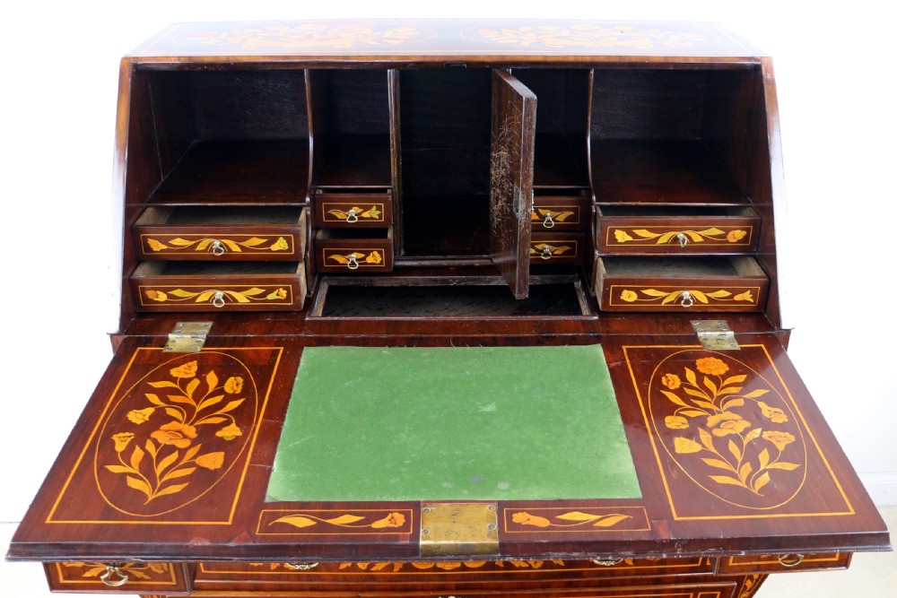 A 19th-century Dutch walnut bombe bureau decorated with intricate floral marquetry, featuring a slant front and curved drawers with brass handles. View XXVII