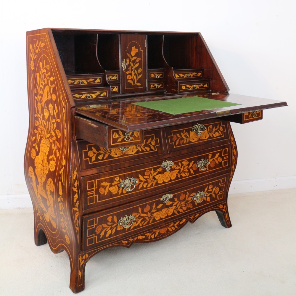A 19th-century Dutch walnut bombe bureau decorated with intricate floral marquetry, featuring a slant front and curved drawers with brass handles. View XXVIII