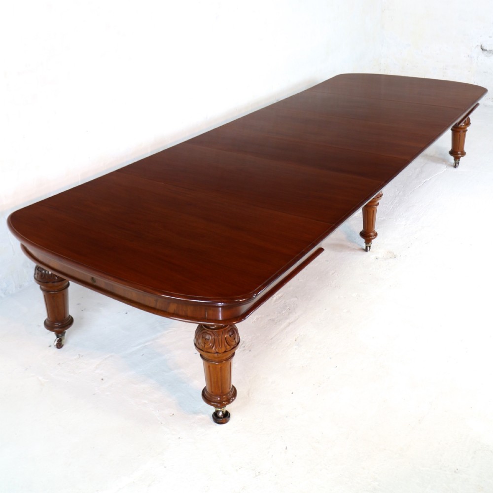 A large Victorian mahogany extending dining table featuring six turned carved legs fitted with brass castors and four removable leaf inserts.