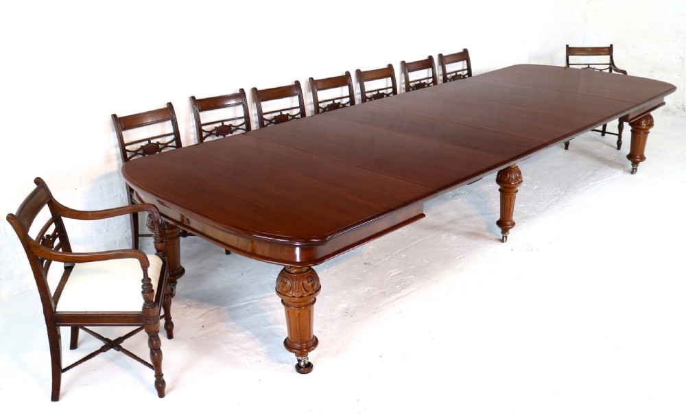 A large Victorian mahogany extending dining table featuring six turned carved legs fitted with brass castors and four removable leaf inserts. View III