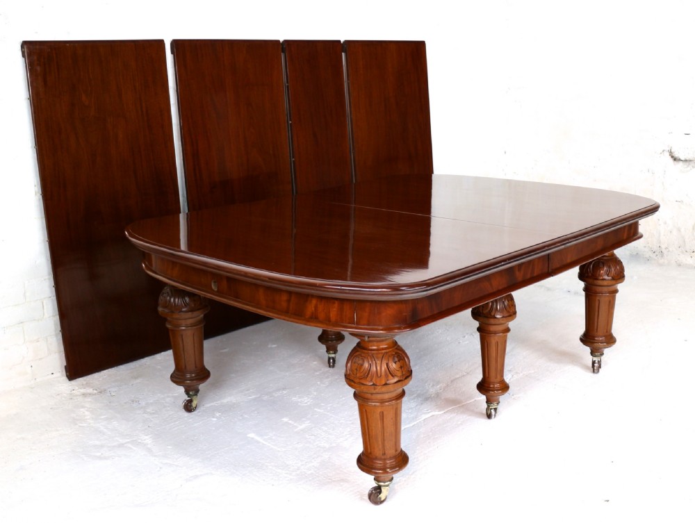 A large Victorian mahogany extending dining table featuring six turned carved legs fitted with brass castors and four removable leaf inserts. View VI