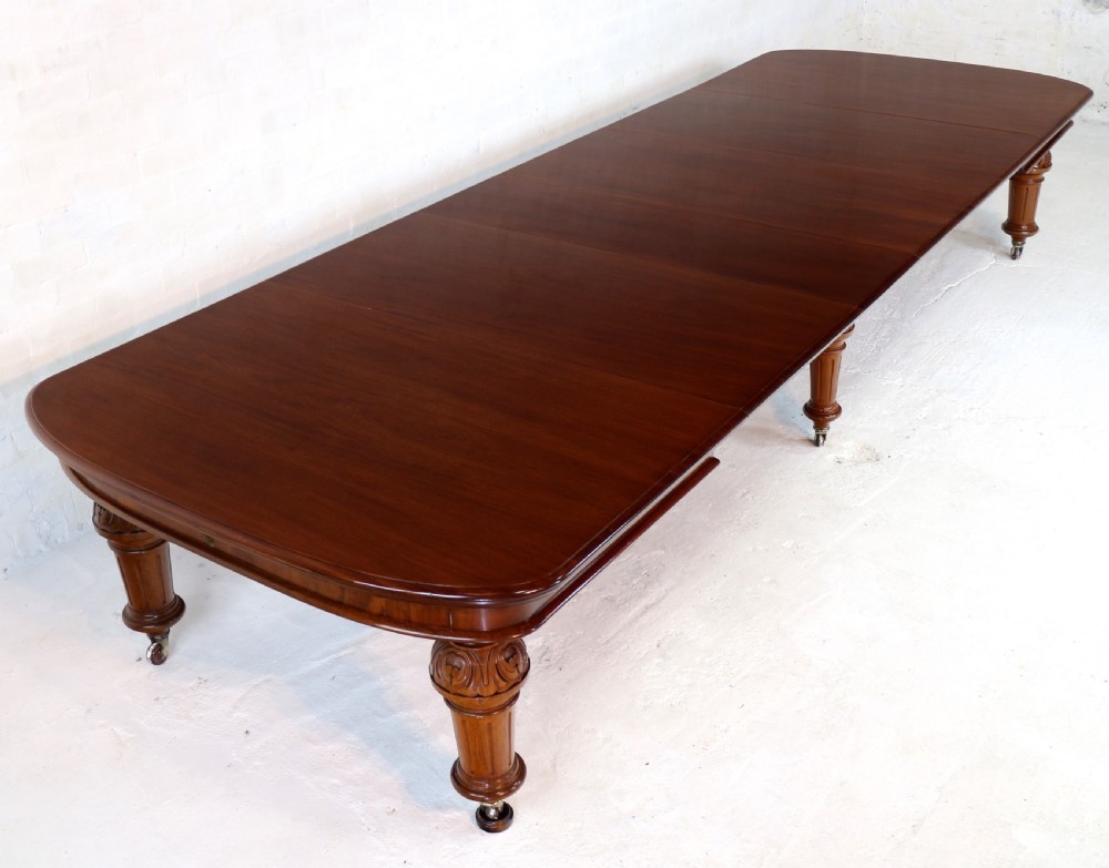 A large Victorian mahogany extending dining table featuring six turned carved legs fitted with brass castors and four removable leaf inserts. View VII