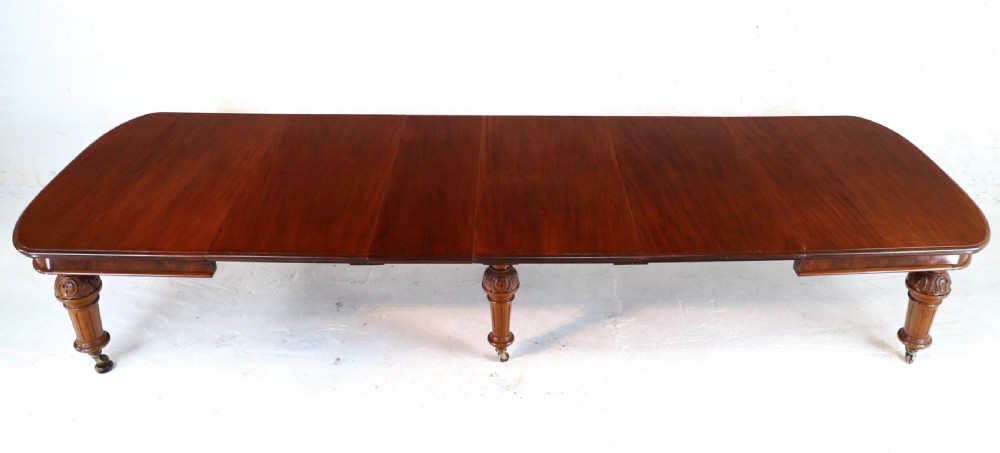 A large Victorian mahogany extending dining table featuring six turned carved legs fitted with brass castors and four removable leaf inserts. View VIII