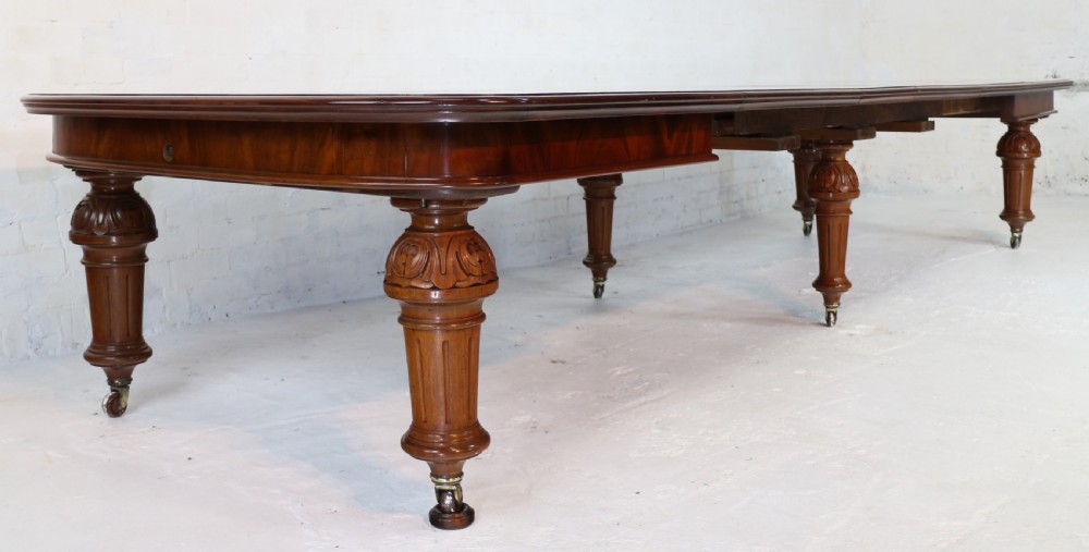 A large Victorian mahogany extending dining table featuring six turned carved legs fitted with brass castors and four removable leaf inserts. View IX