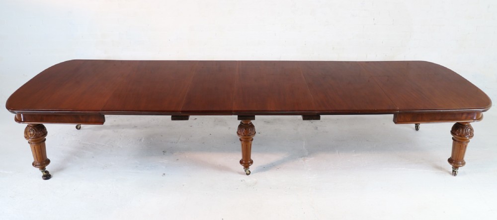 A large Victorian mahogany extending dining table featuring six turned carved legs fitted with brass castors and four removable leaf inserts. View X