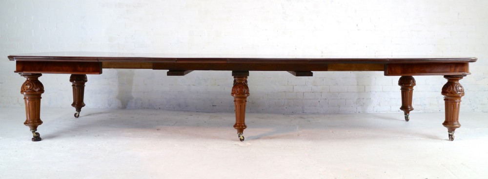 A large Victorian mahogany extending dining table featuring six turned carved legs fitted with brass castors and four removable leaf inserts. View XI