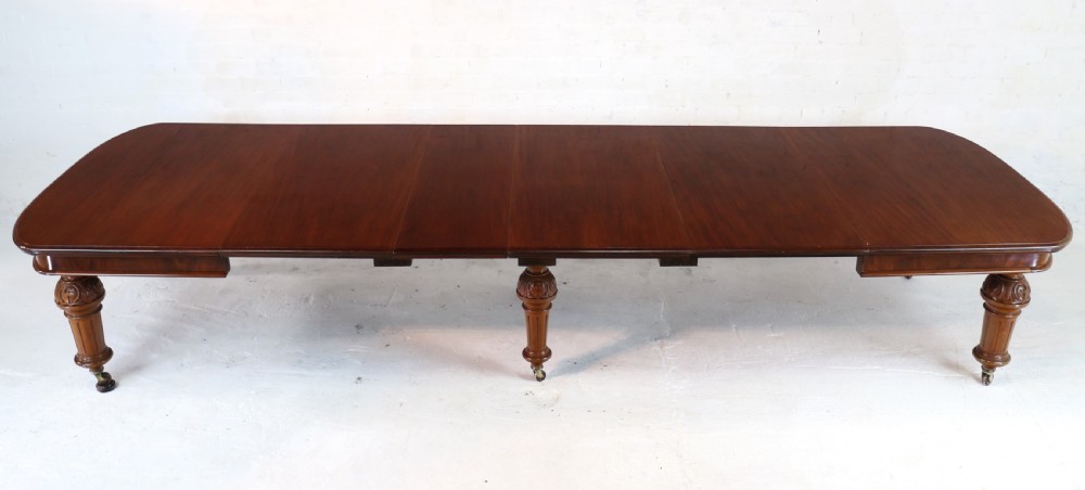 A large Victorian mahogany extending dining table featuring six turned carved legs fitted with brass castors and four removable leaf inserts. View XII