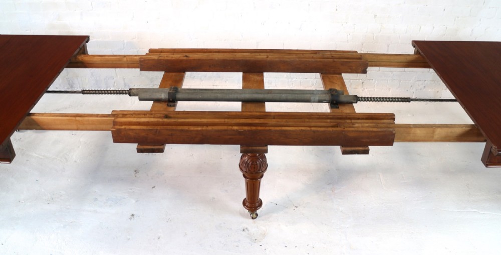 A large Victorian mahogany extending dining table featuring six turned carved legs fitted with brass castors and four removable leaf inserts. View XIV