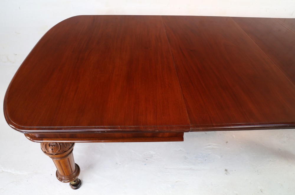 A large Victorian mahogany extending dining table featuring six turned carved legs fitted with brass castors and four removable leaf inserts. View XVI