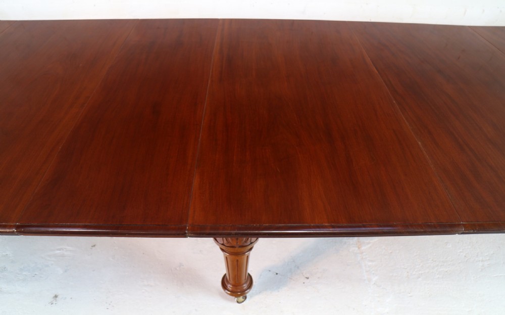 A large Victorian mahogany extending dining table featuring six turned carved legs fitted with brass castors and four removable leaf inserts. View XVII
