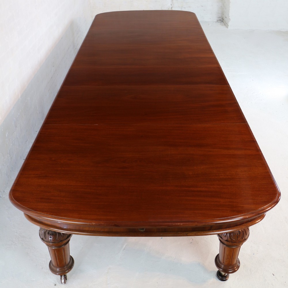 A large Victorian mahogany extending dining table featuring six turned carved legs fitted with brass castors and four removable leaf inserts. View XXII