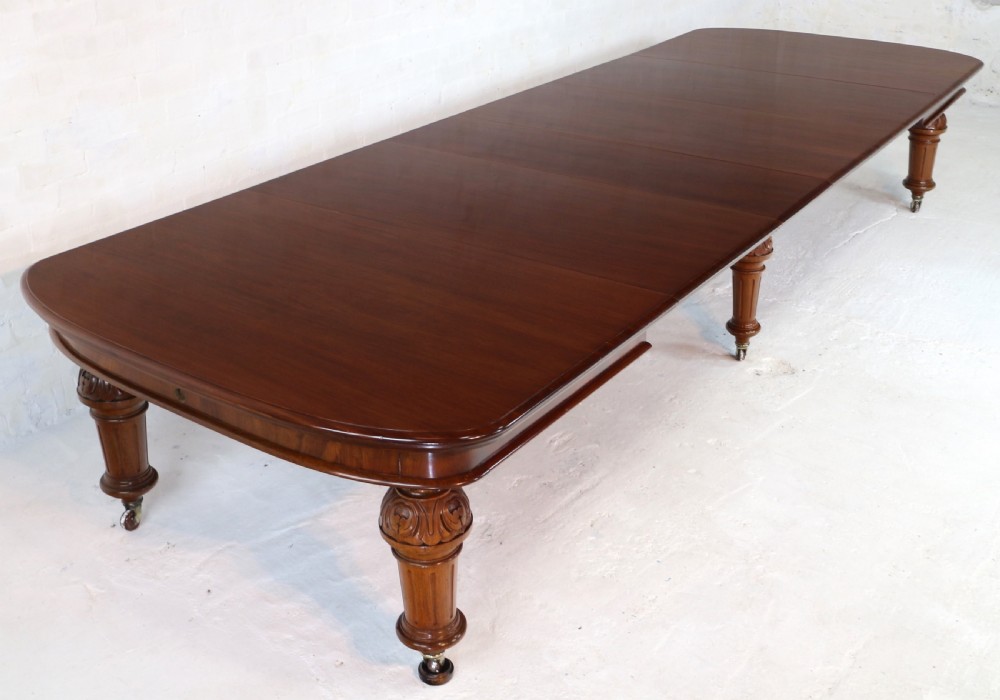 A large Victorian mahogany extending dining table featuring six turned carved legs fitted with brass castors and four removable leaf inserts. View XXIII
