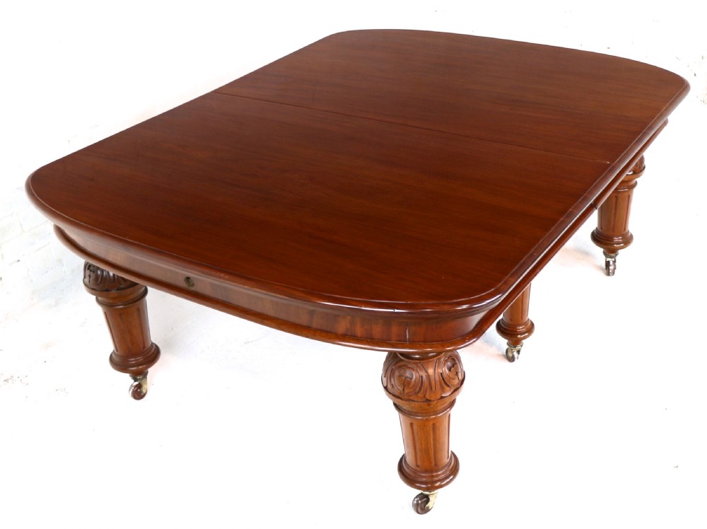 A large Victorian mahogany extending dining table featuring six turned carved legs fitted with brass castors and four removable leaf inserts. View XXIV