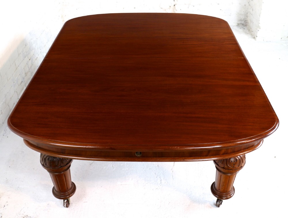 A large Victorian mahogany extending dining table featuring six turned carved legs fitted with brass castors and four removable leaf inserts. View XXV