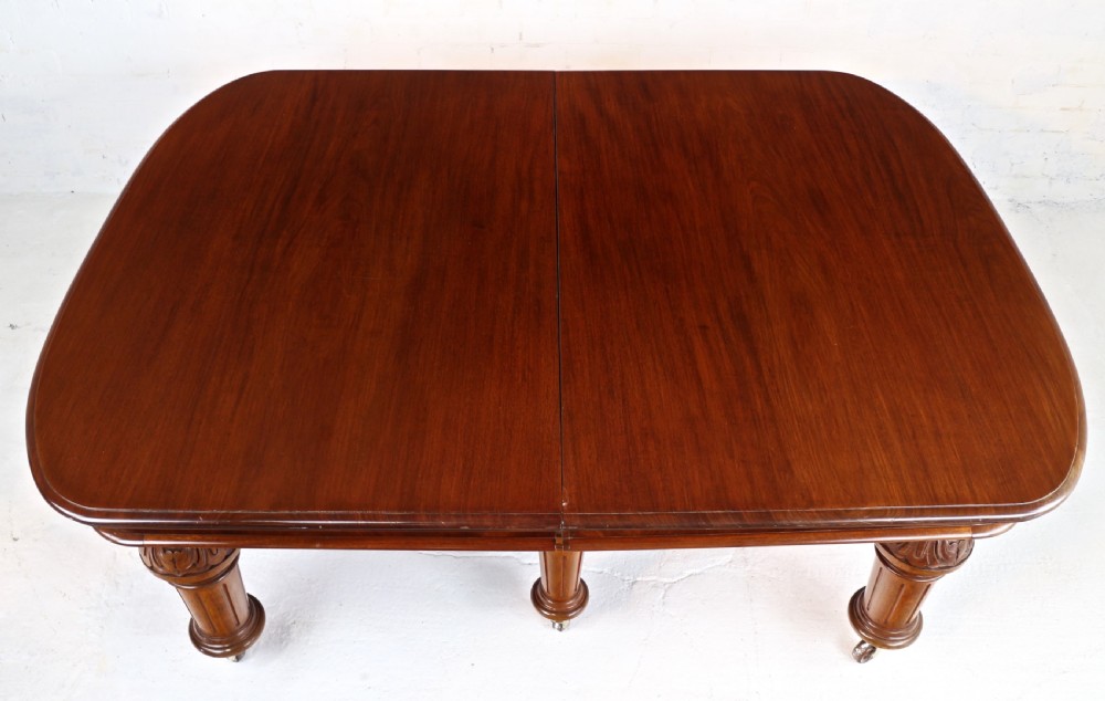 A large Victorian mahogany extending dining table featuring six turned carved legs fitted with brass castors and four removable leaf inserts. View XXVI