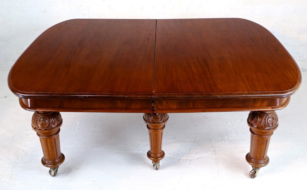 A large Victorian mahogany extending dining table featuring six turned carved legs fitted with brass castors and four removable leaf inserts. View XXIX