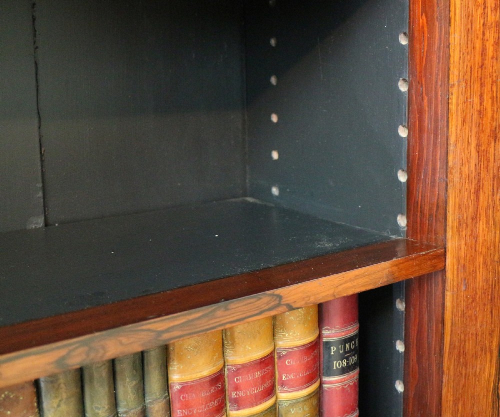 An antique Regency open rosewood bookcase featuring an inverted breakfront profile, multi-tier shelving, and an intricately carved fretwork gallery. View XXIII
