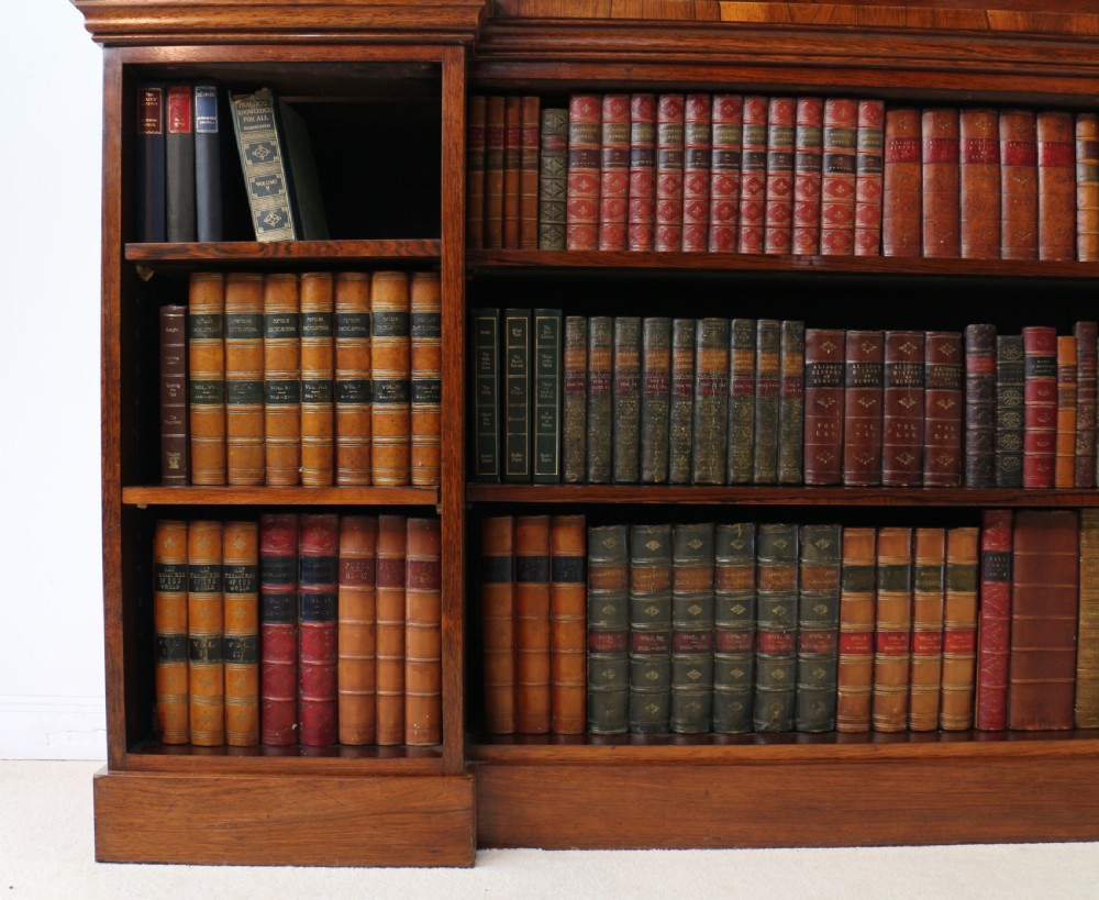 An antique Regency open rosewood bookcase featuring an inverted breakfront profile, multi-tier shelving, and an intricately carved fretwork gallery. View XXVI