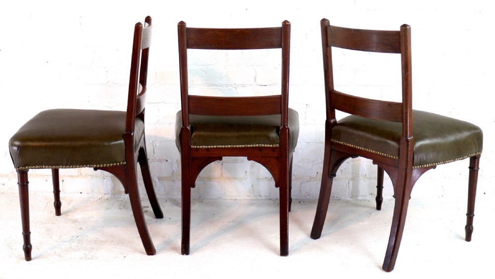 A set of twelve George III mahogany dining chairs featuring rectangular bar-back cresting rails with string inlay, green leather upholstered seats with stud detailing, and turned front legs. View VIII