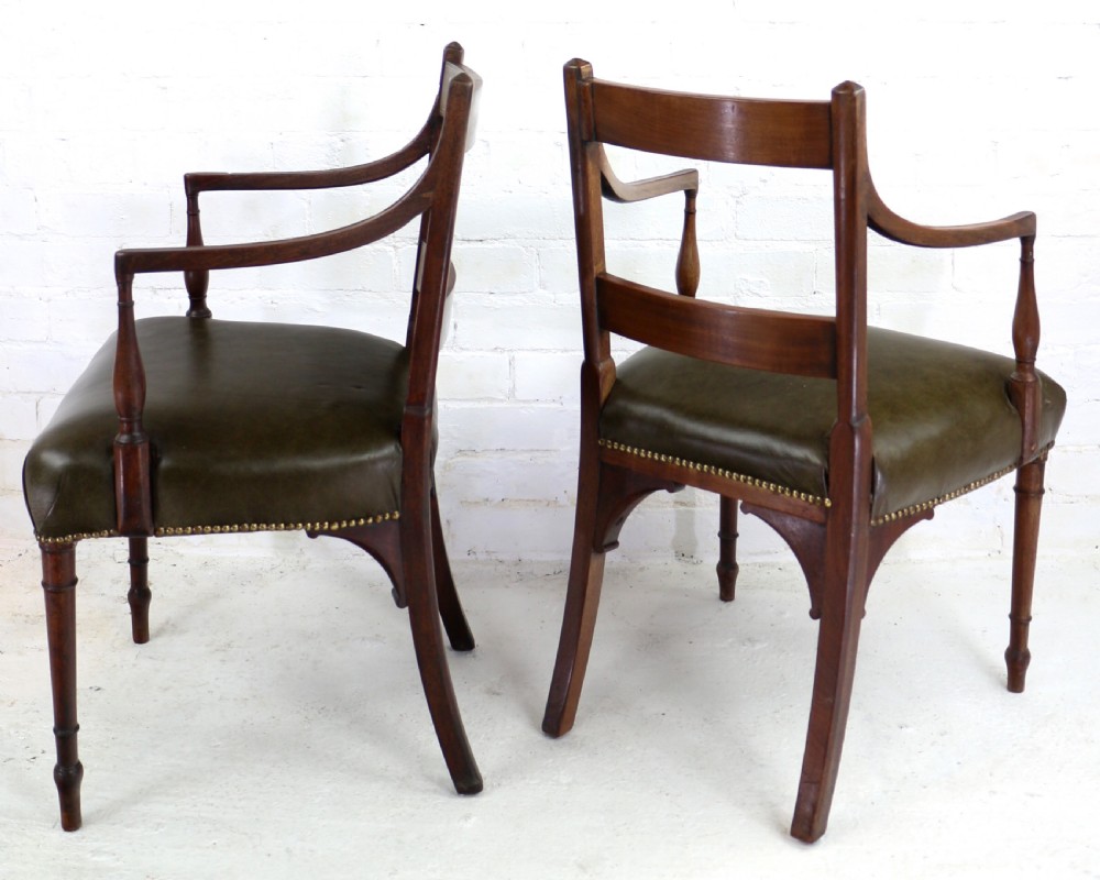 A set of twelve George III mahogany dining chairs featuring rectangular bar-back cresting rails with string inlay, green leather upholstered seats with stud detailing, and turned front legs. View XI
