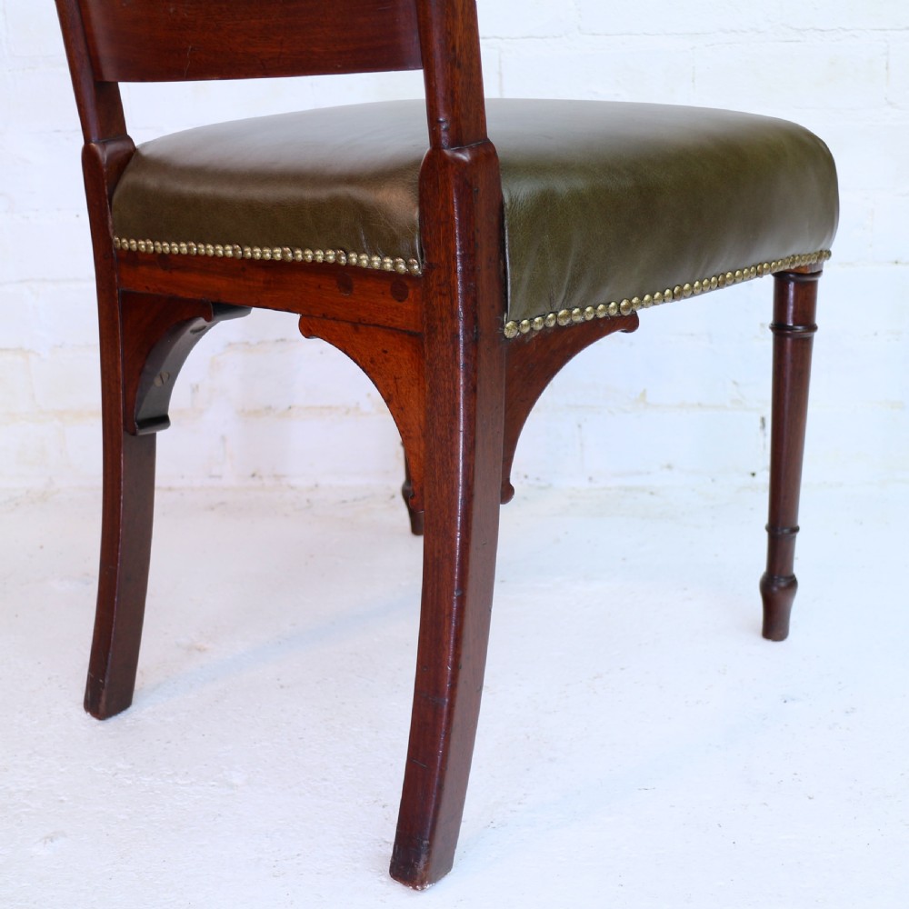 A set of twelve George III mahogany dining chairs featuring rectangular bar-back cresting rails with string inlay, green leather upholstered seats with stud detailing, and turned front legs. View XXI