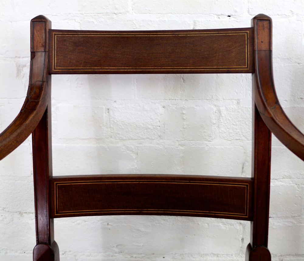 A set of twelve George III mahogany dining chairs featuring rectangular bar-back cresting rails with string inlay, green leather upholstered seats with stud detailing, and turned front legs. View XXIII