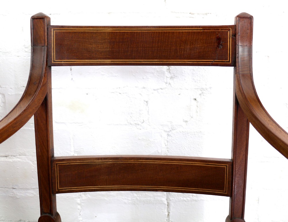 A set of twelve George III mahogany dining chairs featuring rectangular bar-back cresting rails with string inlay, green leather upholstered seats with stud detailing, and turned front legs. View XXIV