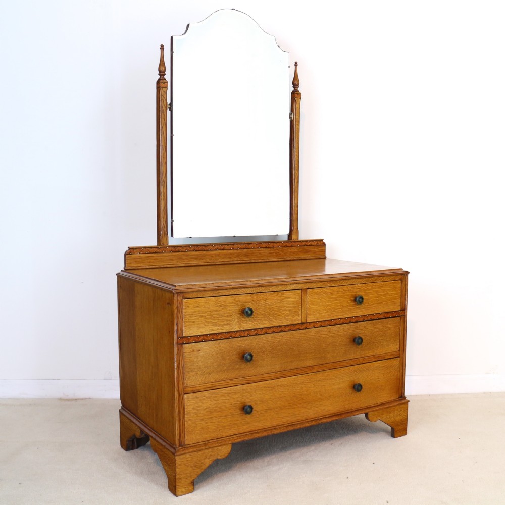 A three-piece golden oak Art Deco bedroom suite featuring a double wardrobe, dressing table with an arched mirror, and a small cupboard chest, all decorated with marquetry medallions. View XII
