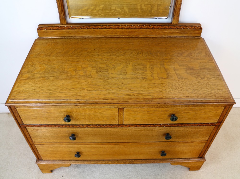 A three-piece golden oak Art Deco bedroom suite featuring a double wardrobe, dressing table with an arched mirror, and a small cupboard chest, all decorated with marquetry medallions. View XVIII