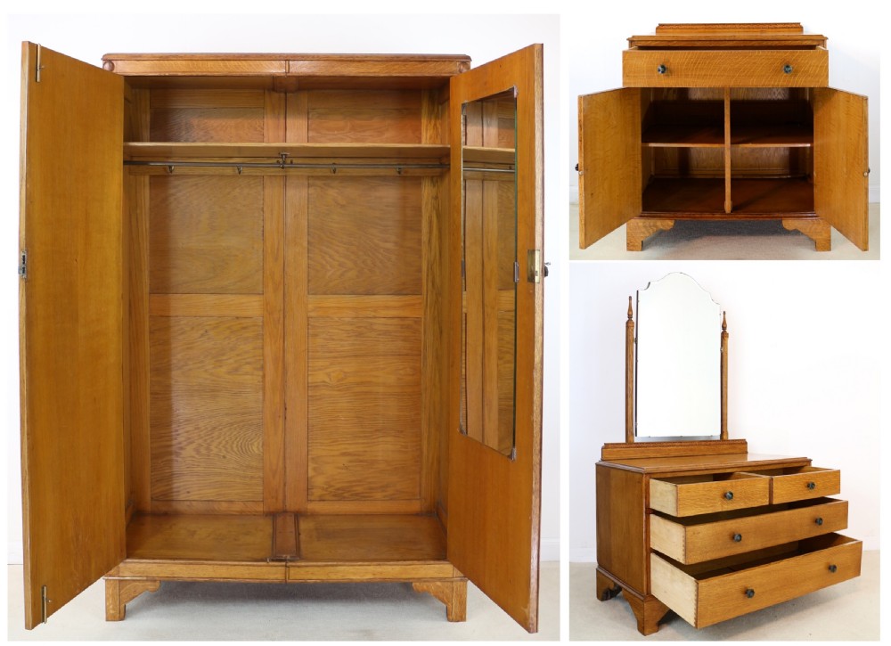 A three-piece golden oak Art Deco bedroom suite featuring a double wardrobe, dressing table with an arched mirror, and a small cupboard chest, all decorated with marquetry medallions. View XXX