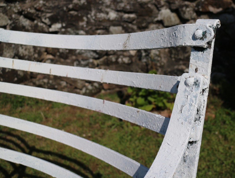 A pair of long white painted wrought iron Victorian garden benches with slatted backs and seats and scrolled armrests. View XIV