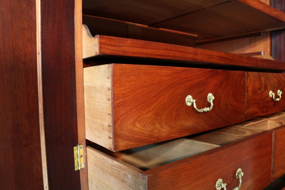 A nineteenth-century breakfront wardrobe featuring flame mahogany veneer, four arched panel doors, and a moulded projecting cornice. View XVI