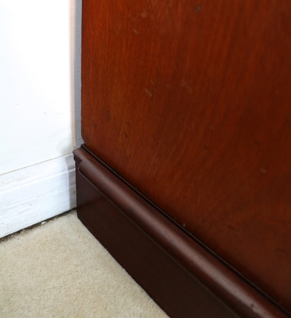 A nineteenth-century breakfront wardrobe featuring flame mahogany veneer, four arched panel doors, and a moulded projecting cornice. View XXVIII
