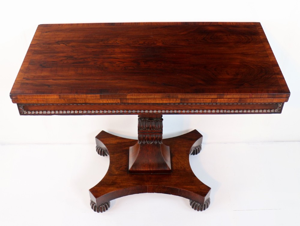 A Regency rosewood tea table featuring a rectangular fold-over top, bead moulding trim, a carved central pedestal, and a quadform base on carved feet. View III