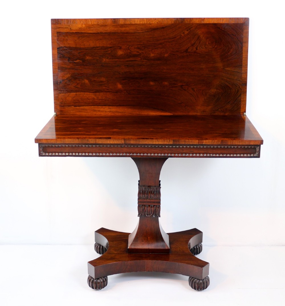 A Regency rosewood tea table featuring a rectangular fold-over top, bead moulding trim, a carved central pedestal, and a quadform base on carved feet. View XIII