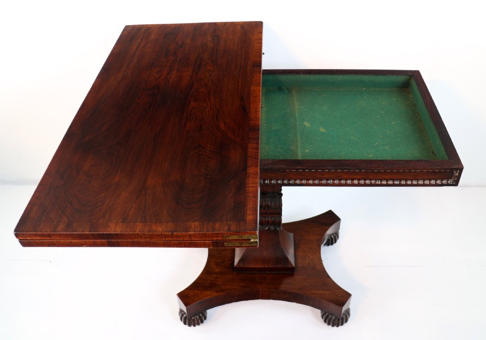 A Regency rosewood tea table featuring a rectangular fold-over top, bead moulding trim, a carved central pedestal, and a quadform base on carved feet. View XIV