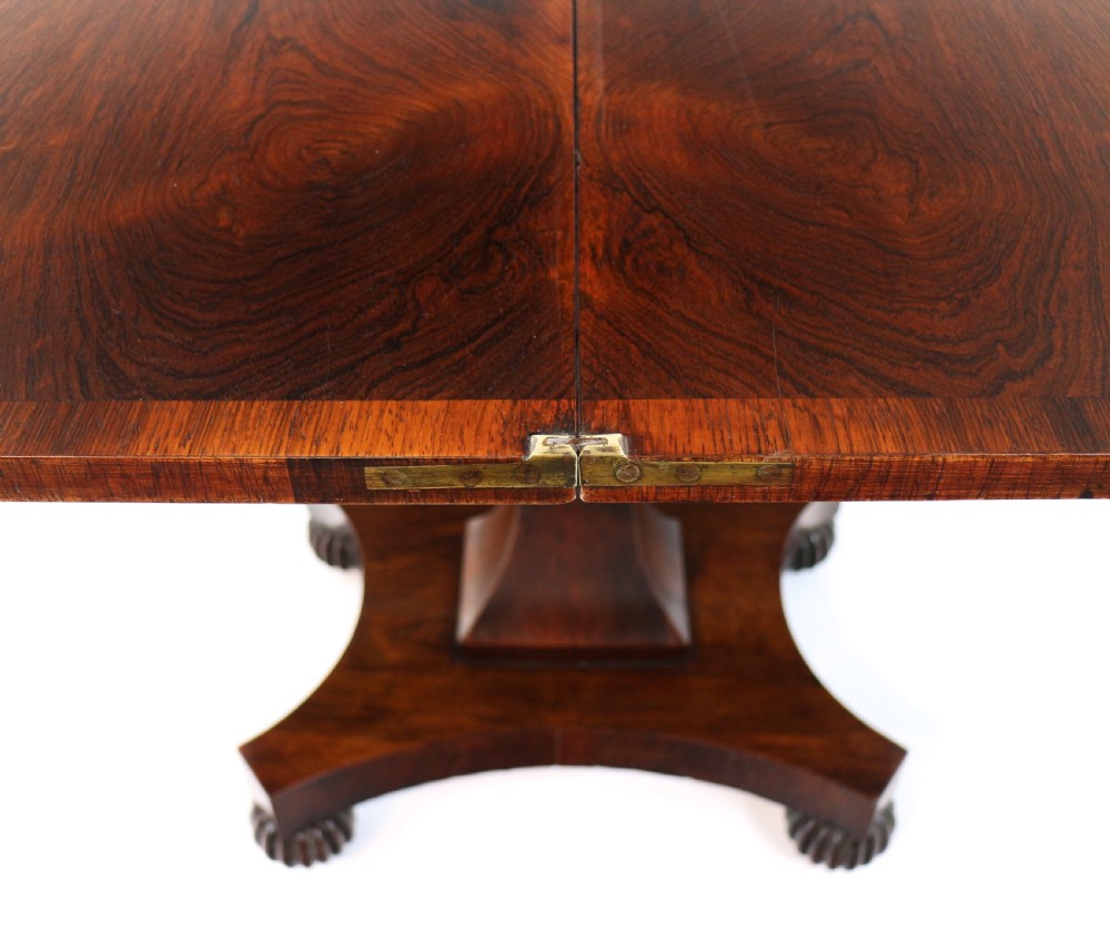 A Regency rosewood tea table featuring a rectangular fold-over top, bead moulding trim, a carved central pedestal, and a quadform base on carved feet. View XVIII