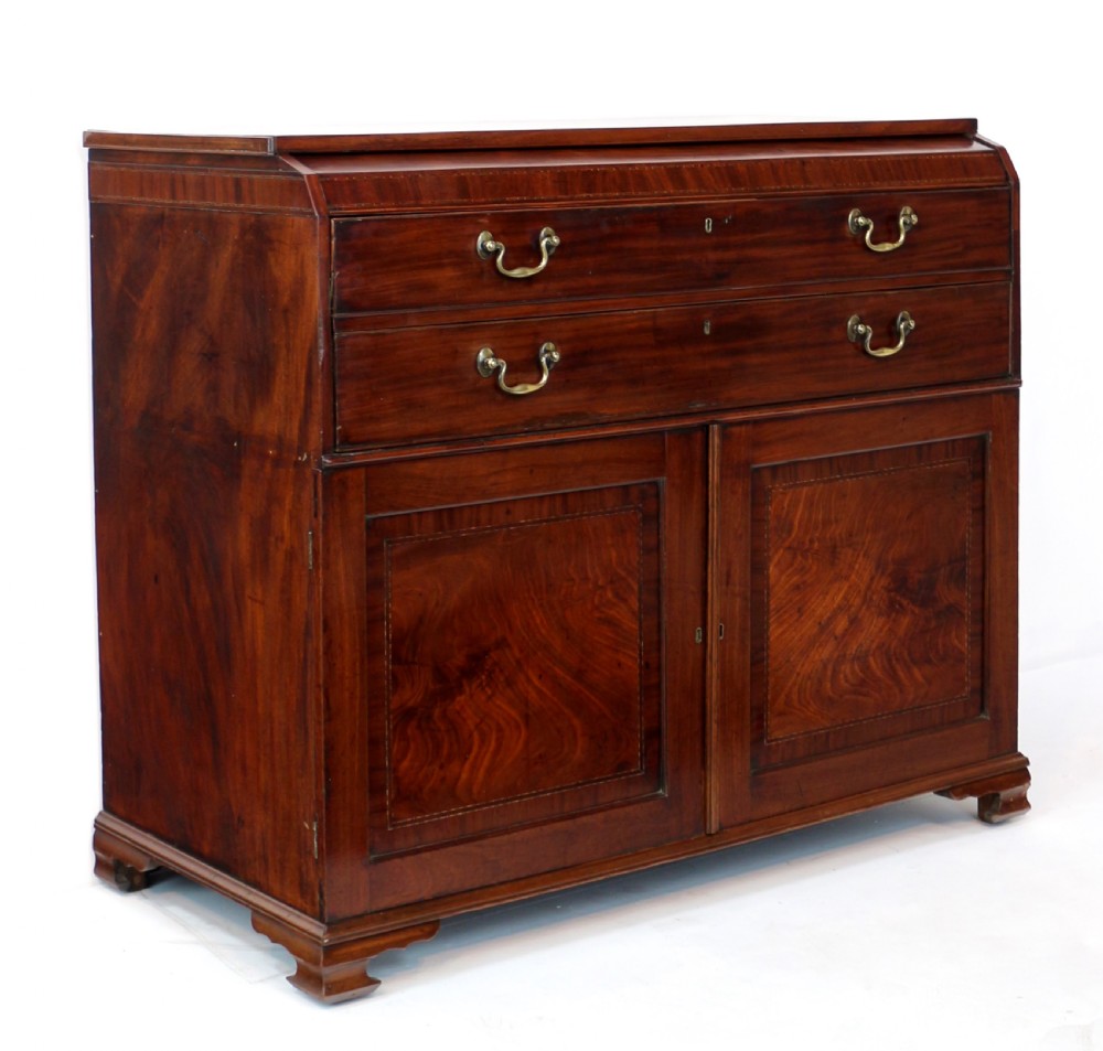 A George III mahogany secretaire low press cupboard featuring flame mahogany veneer panels, brass swan-neck handles, and bracket feet.