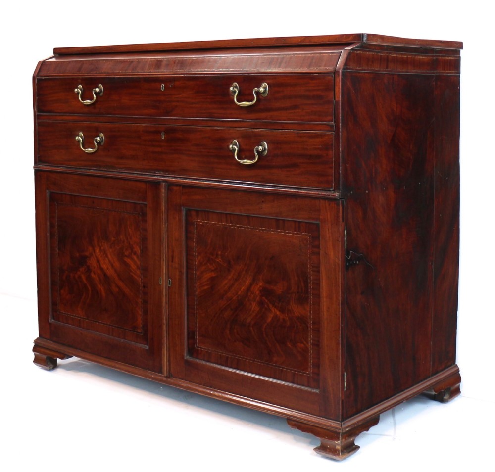 A George III mahogany secretaire low press cupboard featuring flame mahogany veneer panels, brass swan-neck handles, and bracket feet. View II