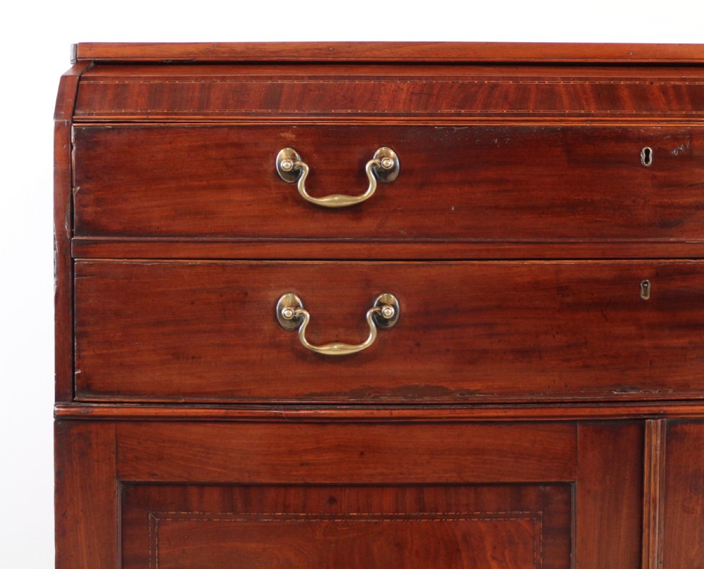 A George III mahogany secretaire low press cupboard featuring flame mahogany veneer panels, brass swan-neck handles, and bracket feet. View III