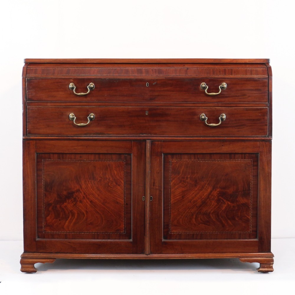 A George III mahogany secretaire low press cupboard featuring flame mahogany veneer panels, brass swan-neck handles, and bracket feet. View VII